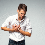 A man clutching the right side of his chest, displaying a pained expression, indicating distress