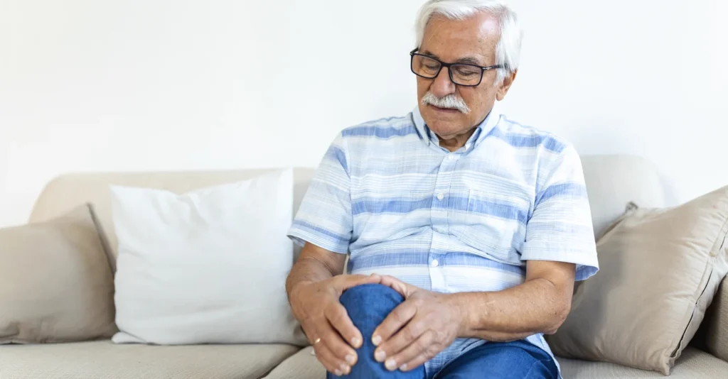 elderly-man-sitting-sofa-home-touching-his-painful-knee