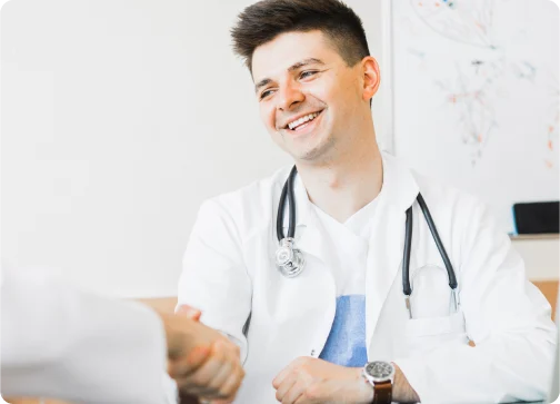 A doctor and patient shaking hands in a professional setting.