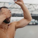 Man splashing water on his face to relieve dehydration.