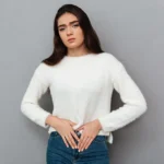 Young woman holding her lower abdomen in discomfort.