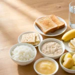 Overhead view of plain rice, bananas, and toast for digestive recovery.