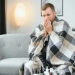 Sick man with flu blowing nose