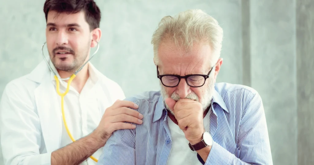 Doctor examining a coughing senior man.
