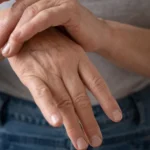 Older woman rubbing hand with pinched nerve